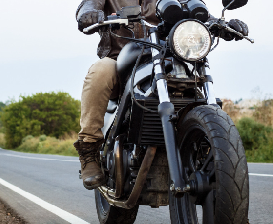 Motocicleta en primer plano, se ven las piernas del conductos sobre la motocicleta
